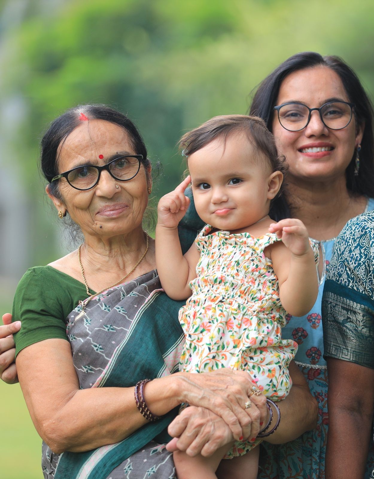 Three generations of one Indian family outdoors: great-grandmother, mother and baby