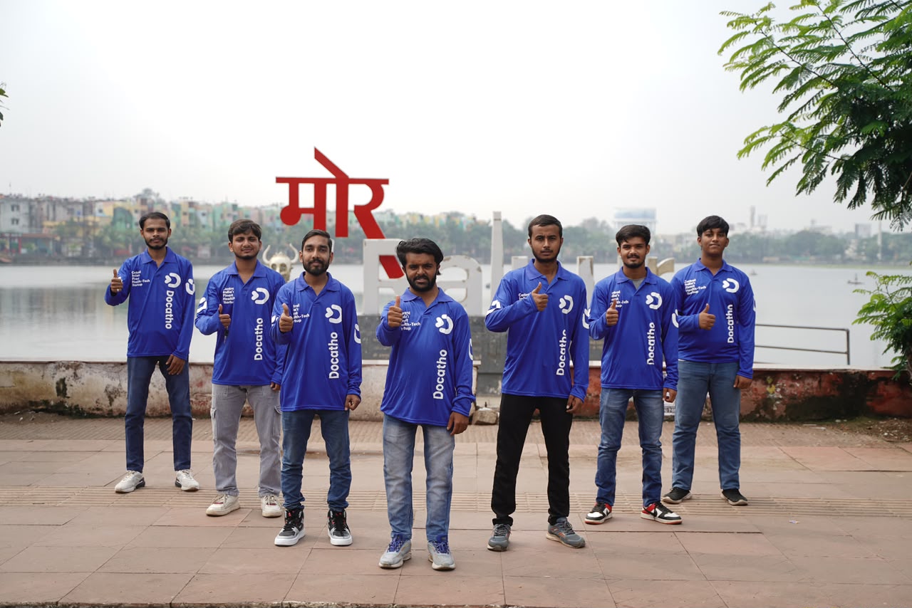 The Docatho fleet in matching blue shirts, thumbs up by the Raipur waterfront